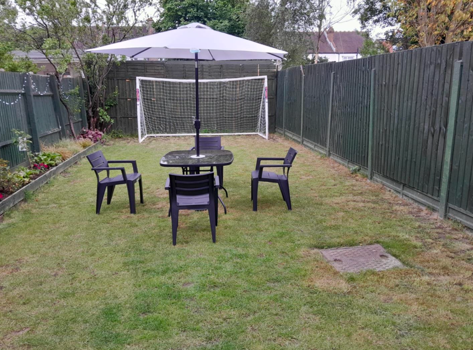Enclosed rear garden with patio seating and a football goal